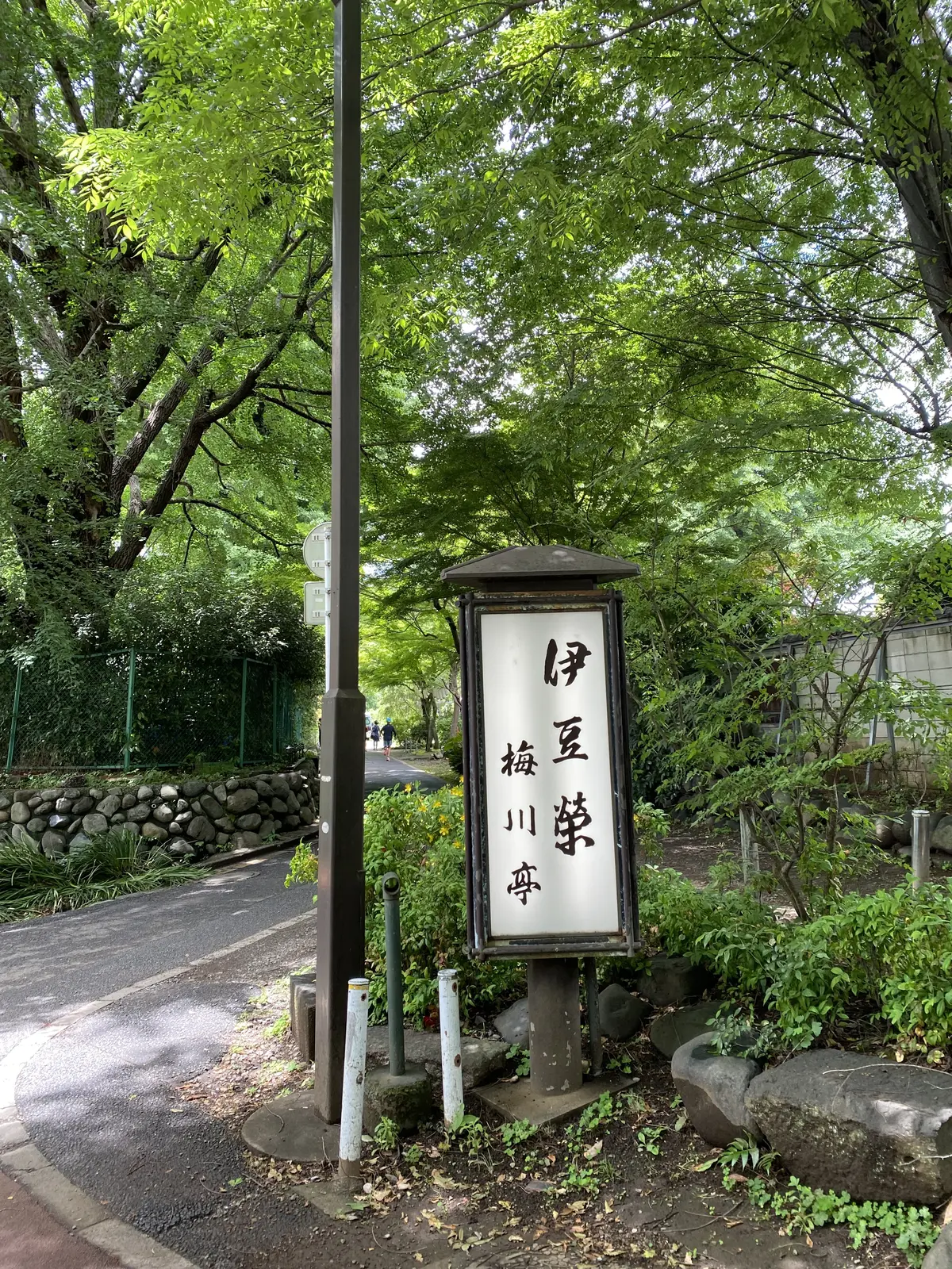 上野・伊豆栄梅川亭の看板が立つ緑豊かな小道