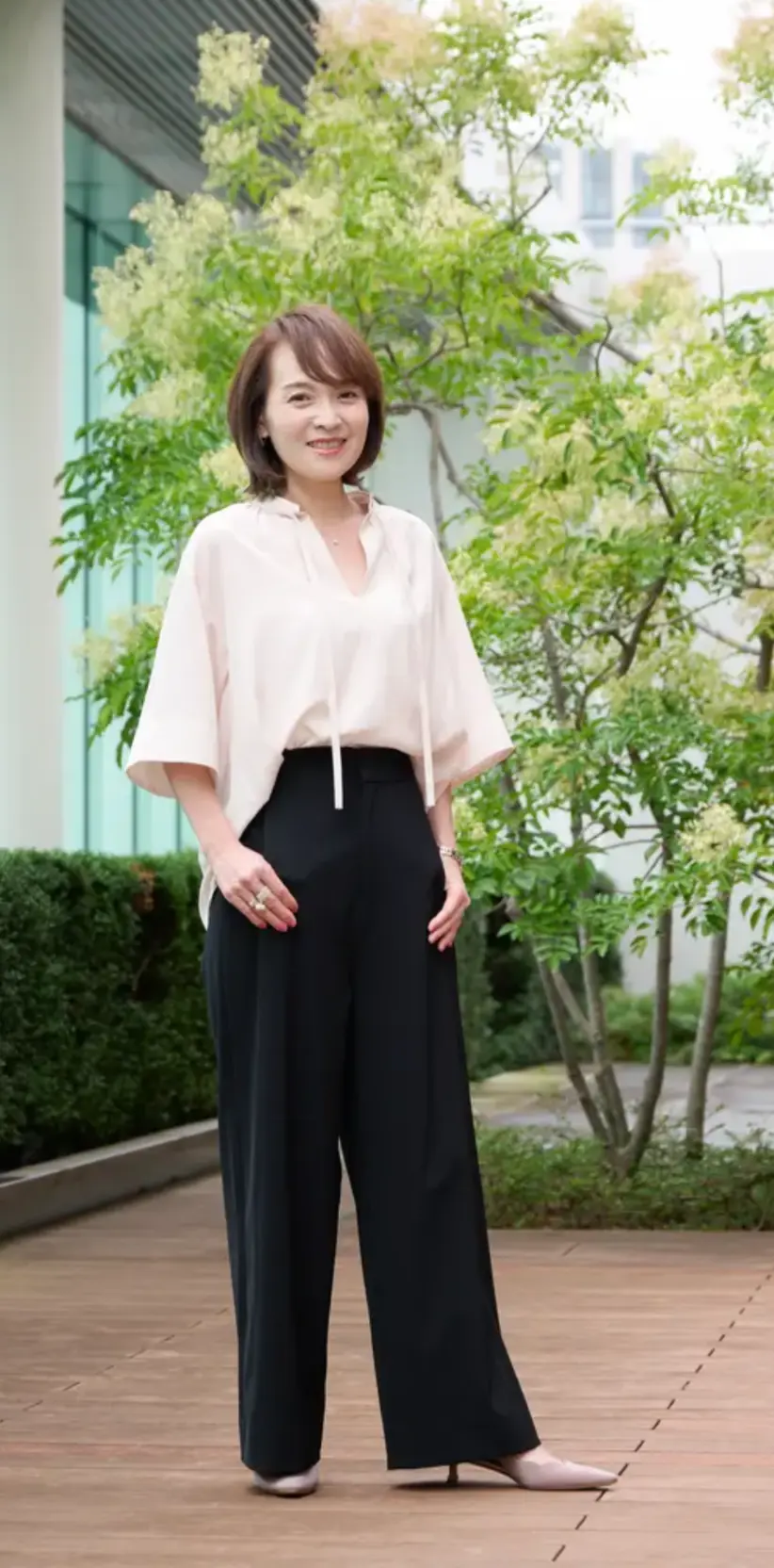 【E by エクラ】の「優美なセミワイドパンツ」を着用する女性