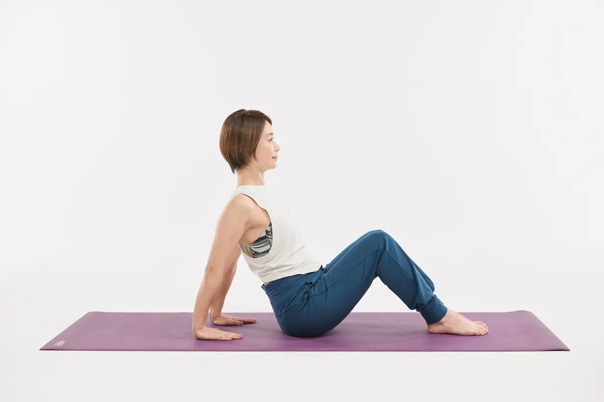 両膝を立てて座り、お尻から手のひら１枚分離した位置に手のひらを置く。指先はお尻のほうに向ける。