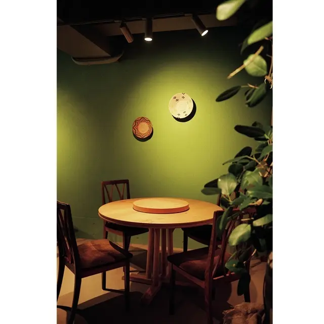 グリーンのトーンカラー、木の家具に観葉植物と異国のヴィラの趣（おもむき）