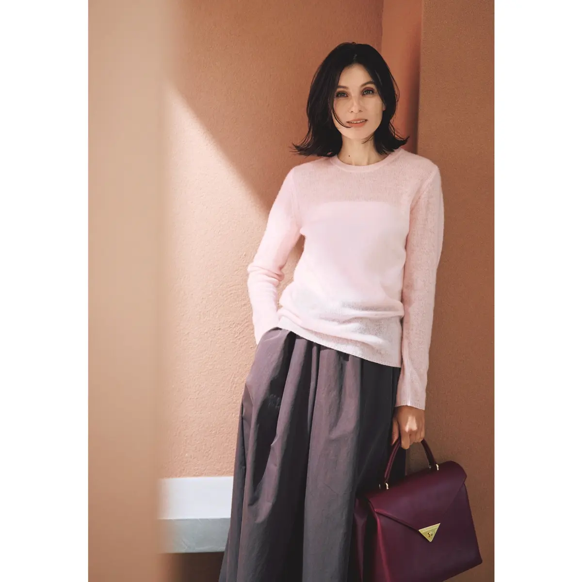 ライトピンクのシアーニットにブラウンのスカートを合わせたコーディネート　モデル・田沢美亜