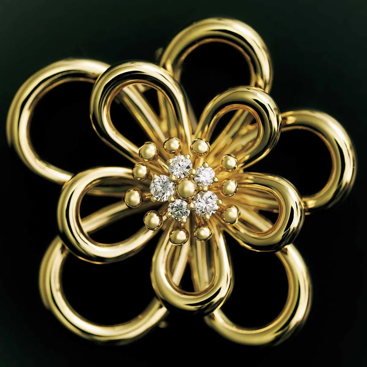 さりげなくアシンメトリーなデザインがのびやかに、立体的に花の輪郭を描いて。チェーンつき。クリップ ペンダント「フラワーレース」 （YG×D）￥3,788,400（予定価格）／ヴァン クリーフ＆アーペル ル デスク（ヴァン クリーフ＆アーペル）