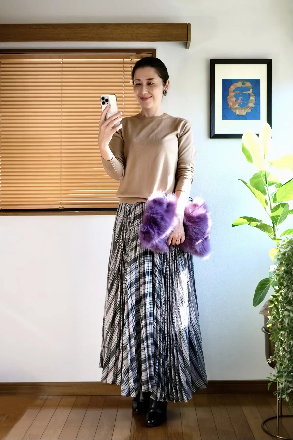 ユニクロのベージュニット、グレーのチェック柄ロングプリーツスカート、黒のショートブーツ、パープルのファーバッグ