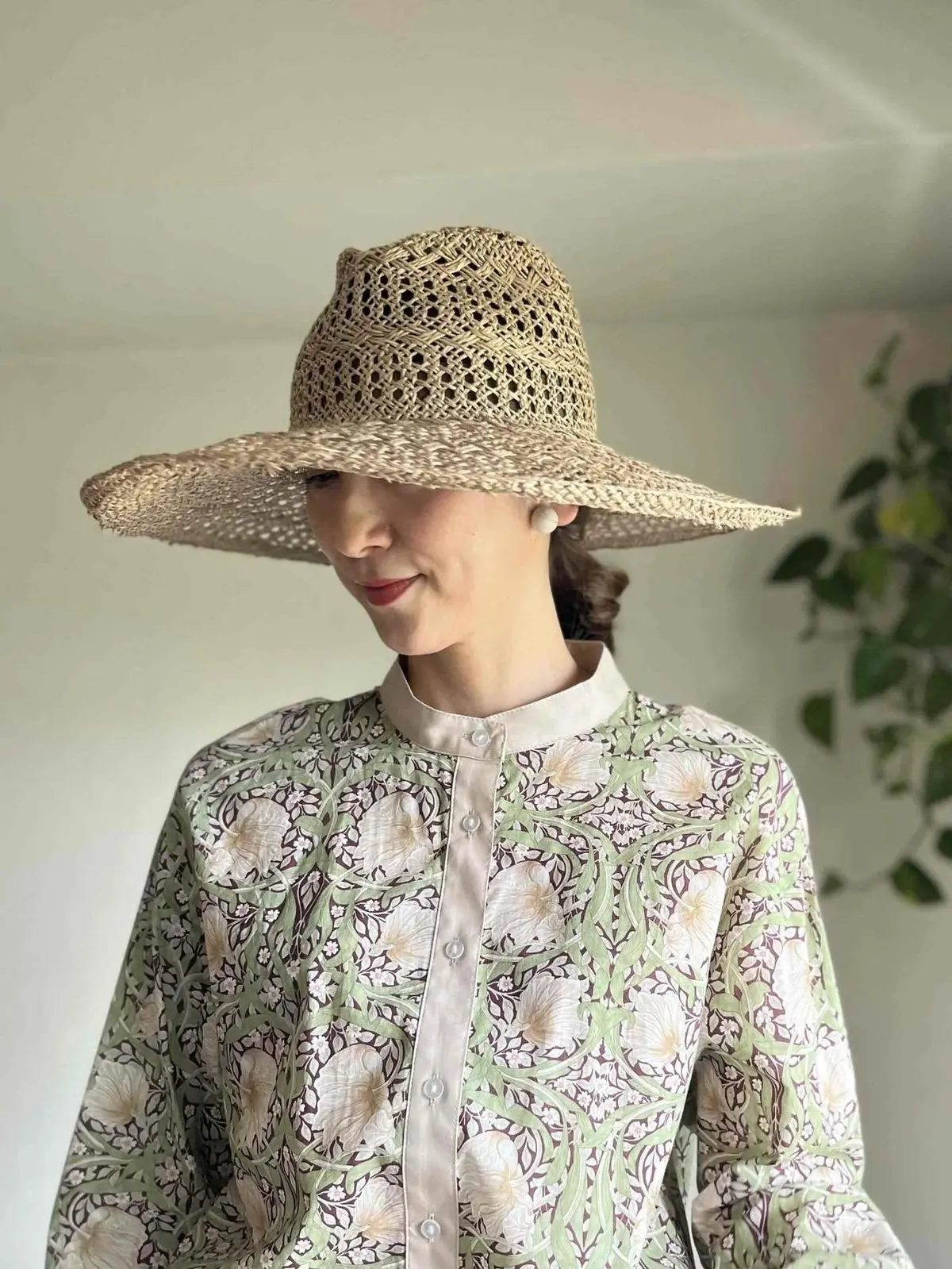 ハットの軽やかな透け感とリンクする、ラフなまとめ髪