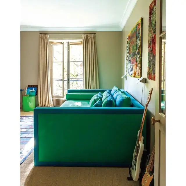 庭側、ダイニングの手前はマリーエレーヌの息子、エドモンの部屋。大きなソファベッドは彼女がもともと持っていた、デヴィッド・ヒックスのデザイン。壁には彼の友人の若手アーティスト、エマ・ソーシックによる絵を飾って