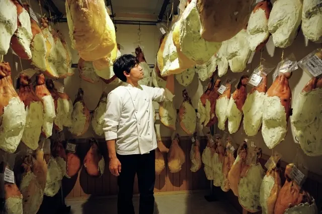 熟成庫で生ハムの状態をチェックする赤石泰洋シェフ。