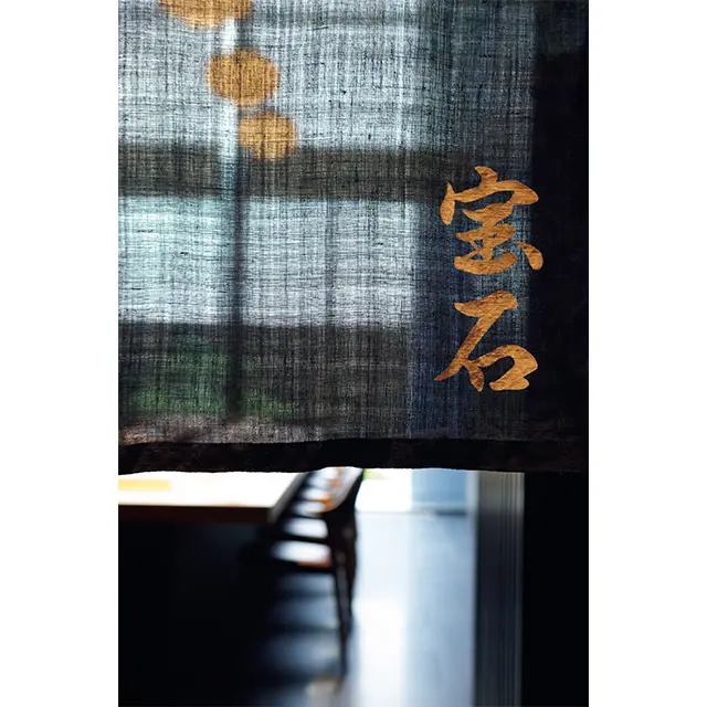 暖簾越しに見る店内。 窓が大きく、昼間は光も美 しい