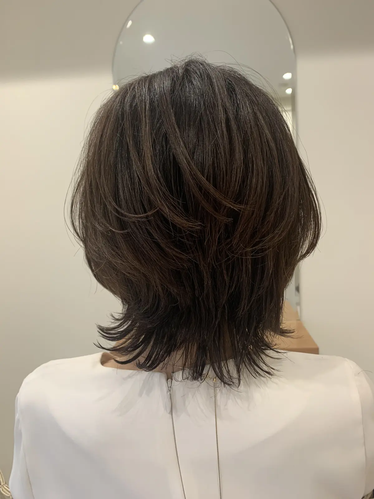 くびれミディアムヘアにカットした50代女性