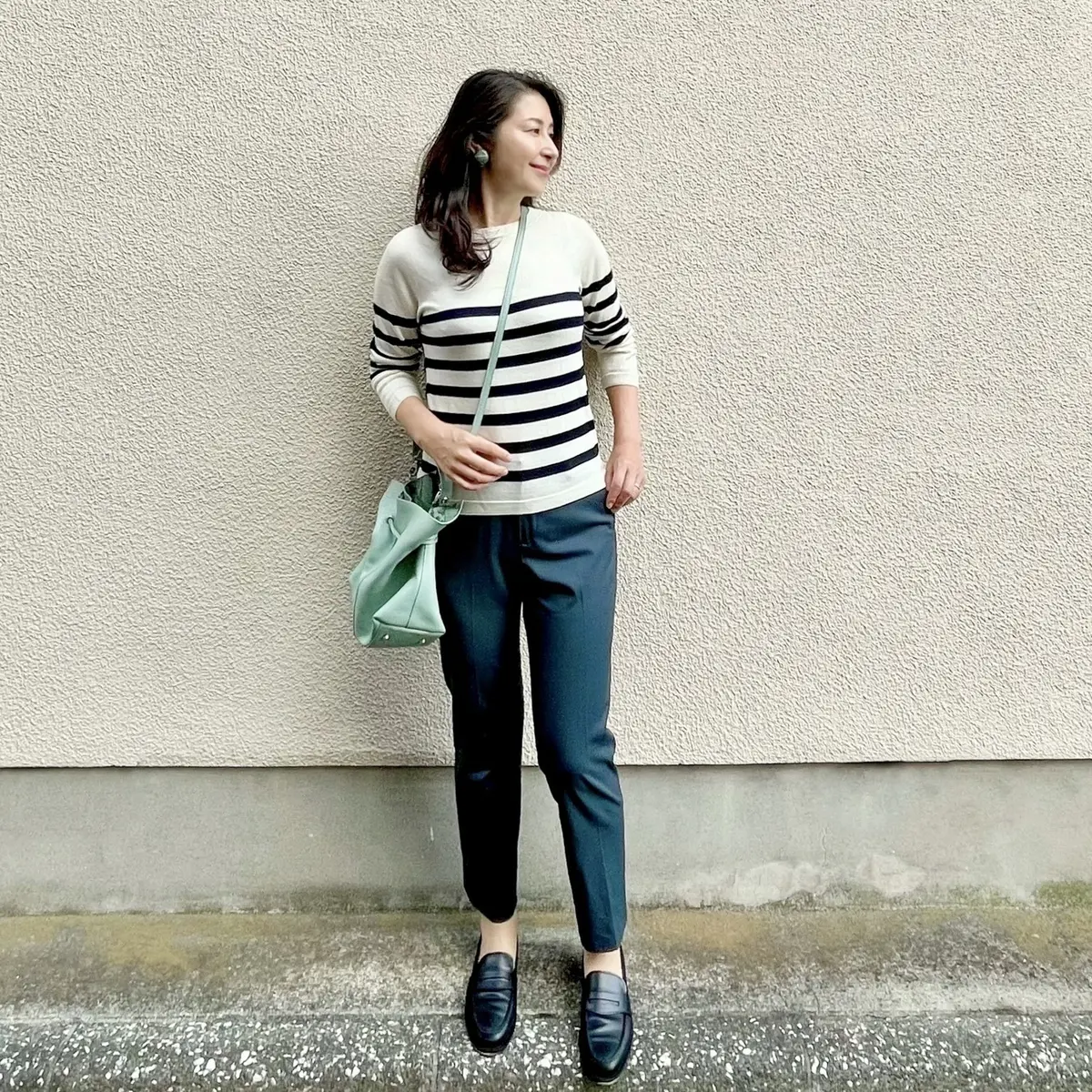 ボーダーニット、グリーンのテーパードパンツ、黒ローファー、ライトグリーンのポシェット