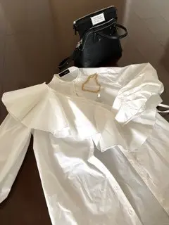 スタイリングの襟付き白ブラウス