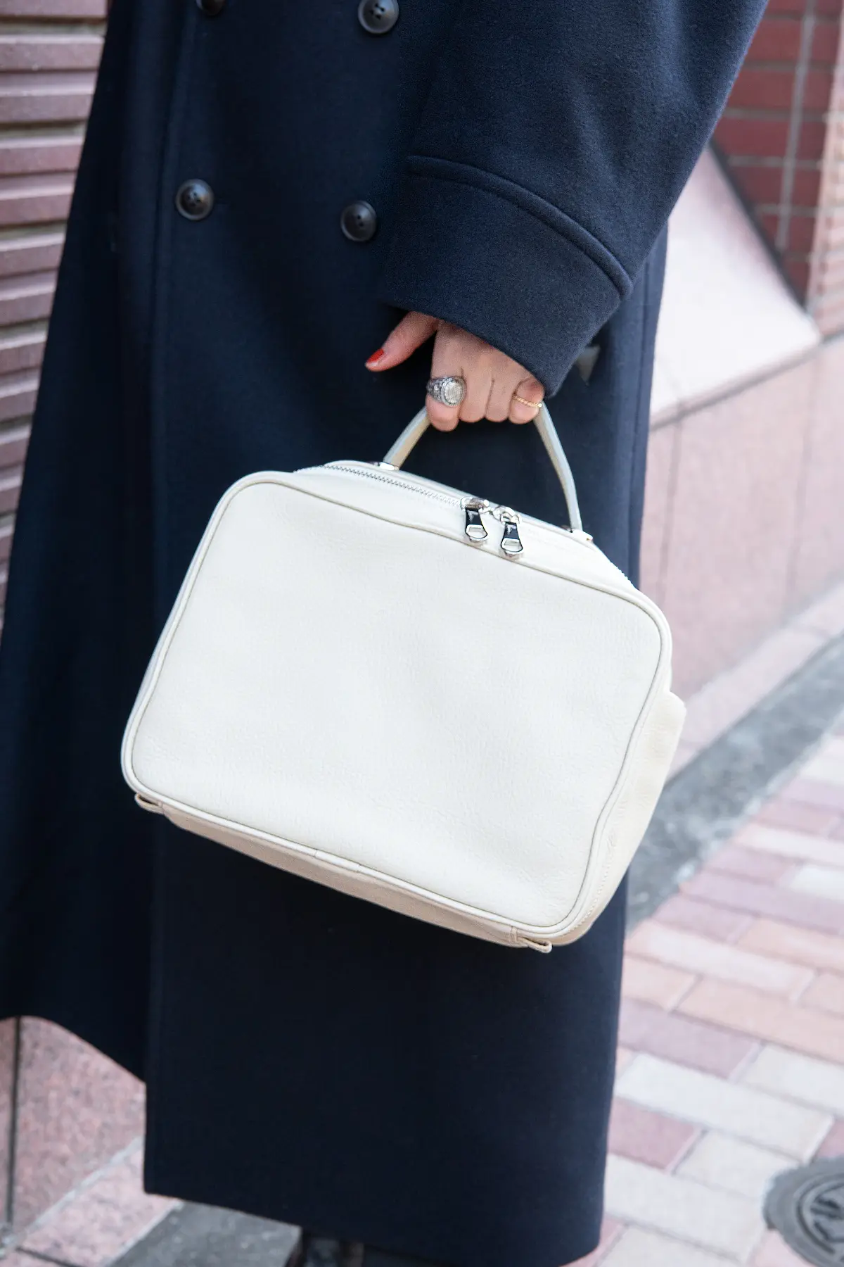 冬の街に映える白いバッグは「ロワン」のもの。