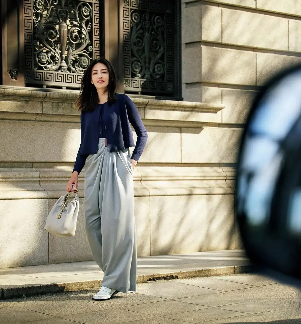 アシンメトリーなドレープがシックな着こなしに主役級の華やぎを