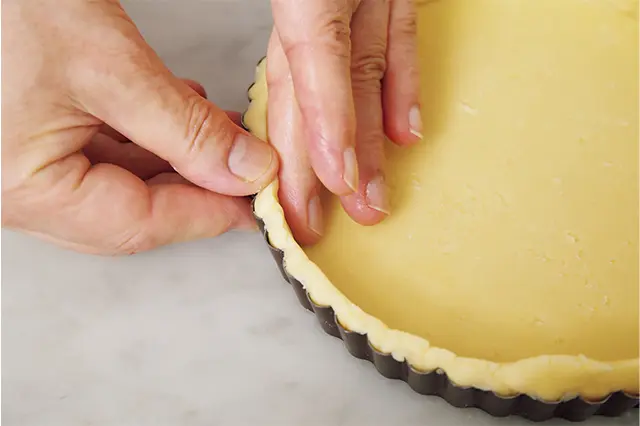 内側面を中指の腹で断面を親指 の腹で同時に押さえ、生地を型 に密着させ、断面を整える。