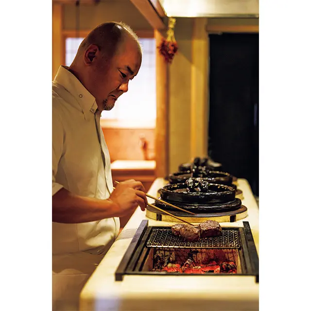 かたまり肉を炭火でじっ くり焼きながら熟成肉のうま味を引き出す月岡さん