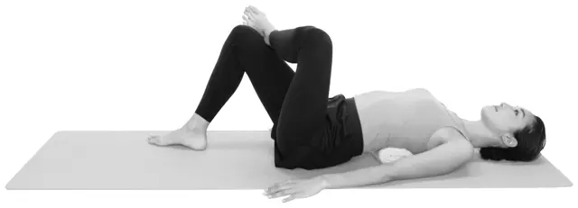 丸めたバスタオルを肩甲骨の下の位置に入れ、左右の腕を床につけた状態で仰向けになる