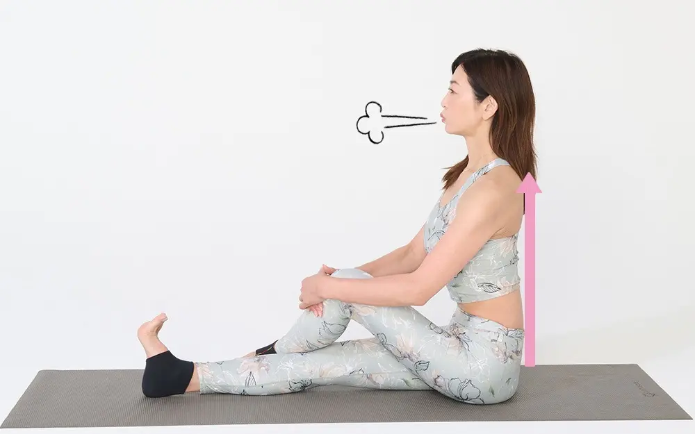 OurAge×Webエクラ　①床に座り、右脚を真っすぐに伸ばして足を90度に曲げ、左脚をクロスさせて右脚の外側につけます。両手で左脚を押さえ、息を吸って、吐きながら背骨を伸ばします。そのまま3〜5呼吸。