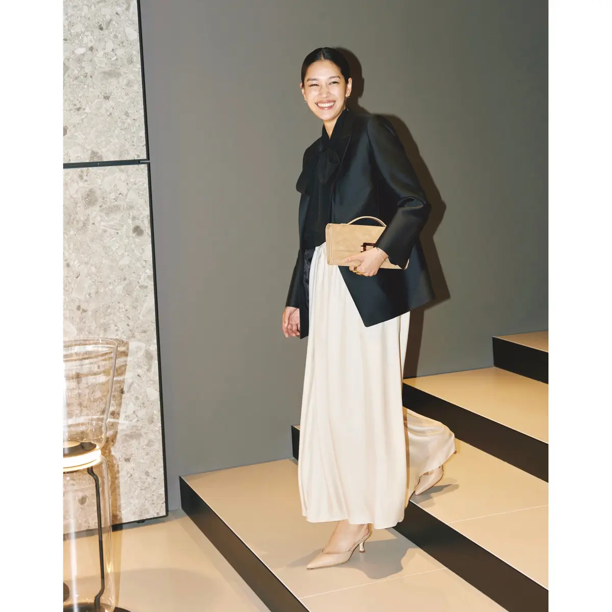 黒のジャケットとボウタイブラウスに白スカートを合わせたモノトーンコーディネート　モデル・大塚まゆか