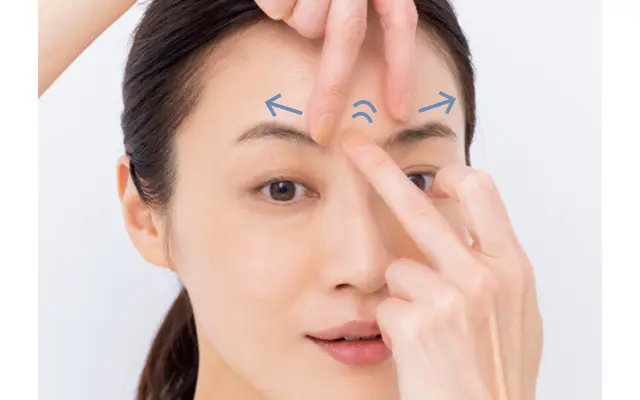 人さし指と中指を上から構え、眉間の肌を左右にのばす。反対の手の中指で美容液を優しく軽くたたき込む。