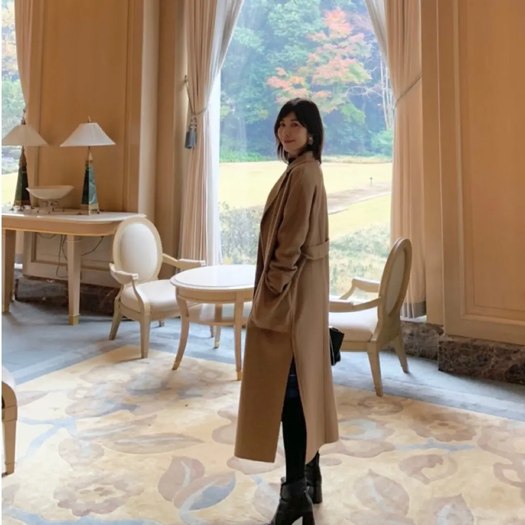 逸品キャメルコートを着てもみの木のツリーの画像_1