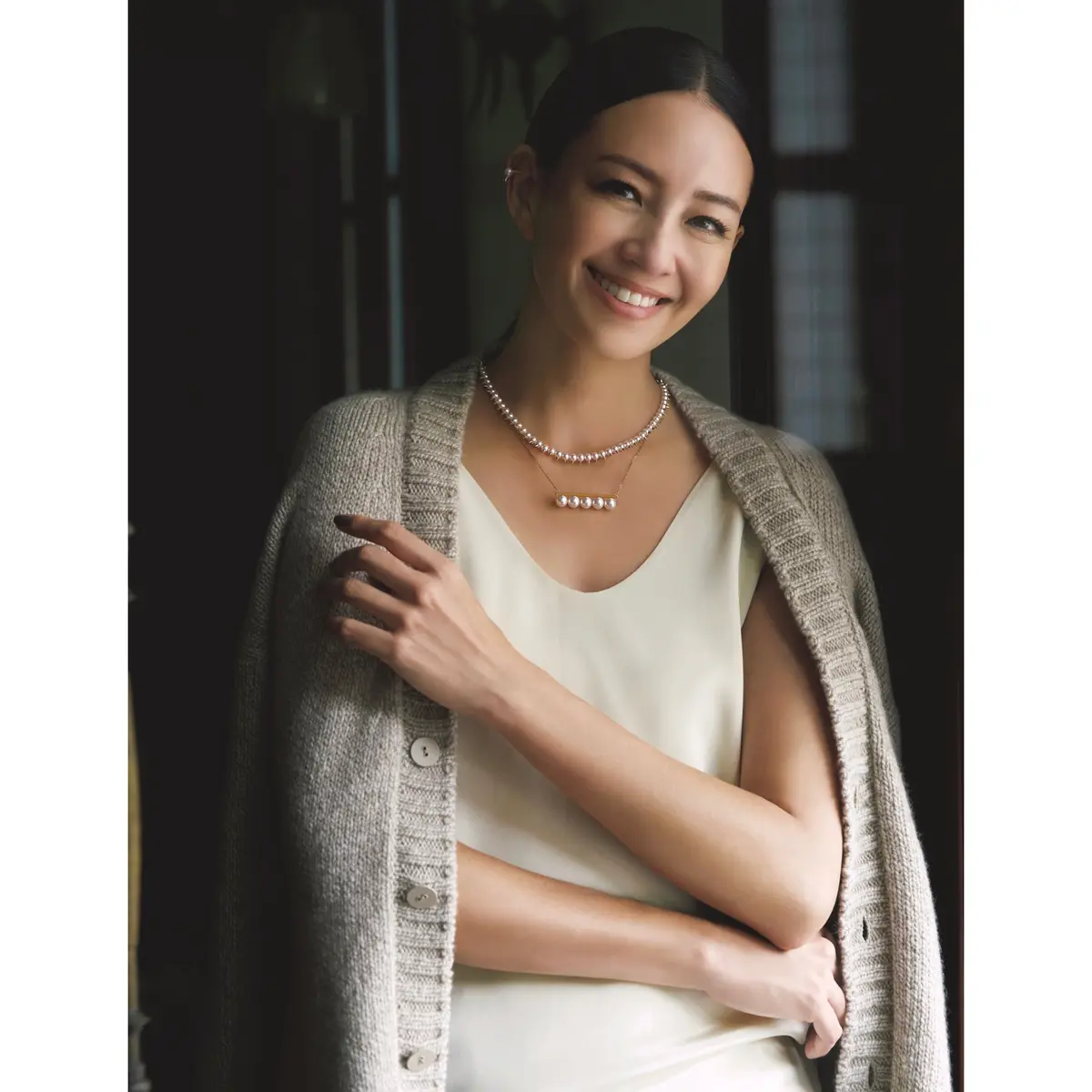 白ノースリーブブラウスにベージュニットカーディガンをはおったコーディネート　モデル・RINA