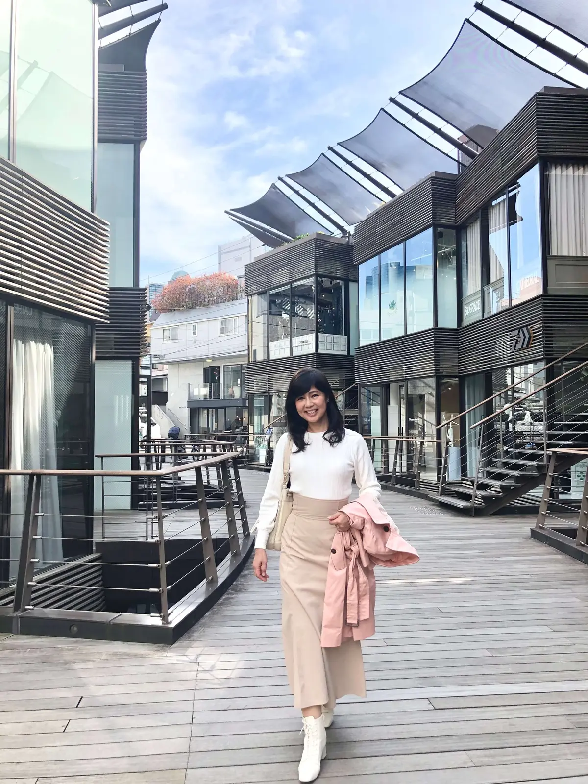 ベージュロングスカート「VIS(ビズ)」、白ニット「Feroux(フェルー)」、ピンクのトレンチコート「any sis(エニシス)」