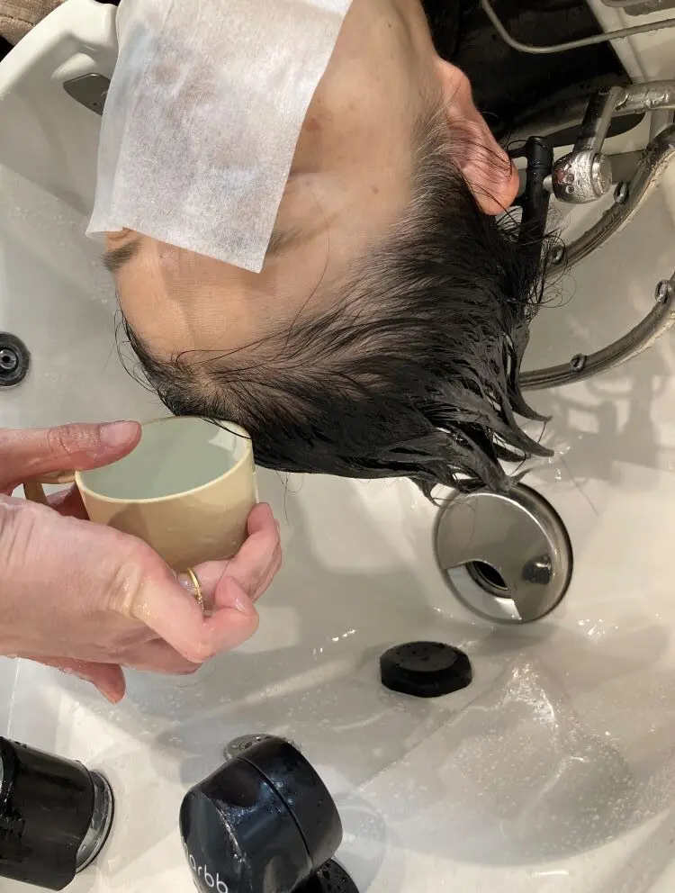 OurAge×Webエクラ　〔上の写真：シャンプーの総仕上げにも、コップでナノバブル入りのお湯をそっと生え際からかける〕