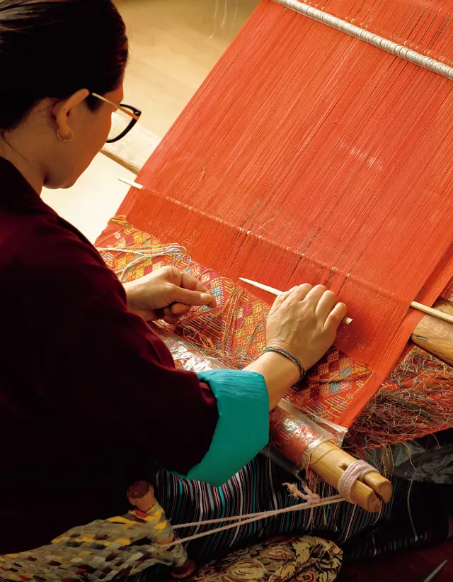 床に座って織る伝統の＂腰機＂で絹織物を作る様子も見られる
