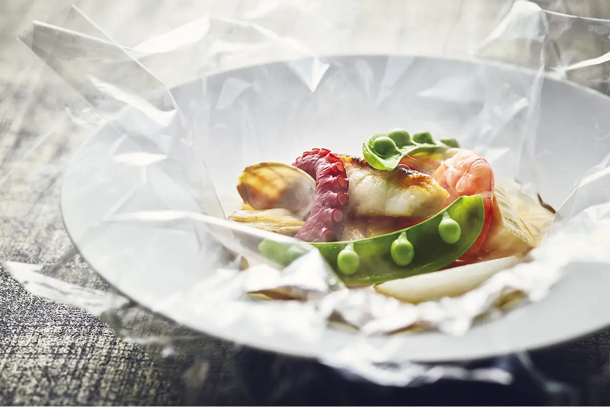 6皿の シグネチャーディナーコース「Blanche」は、 ￥12,500（サ別）。旬の野菜をカルタファタフ ィルムで包み蒸し焼きにし、中華のアレンジ をきかせたスープとともにいただく魚料理な ど、地元の食材や食文化と、異文化の交わり を感じるサプライズな美食をどうぞ。ランチ とディナーはビジター利用も可　