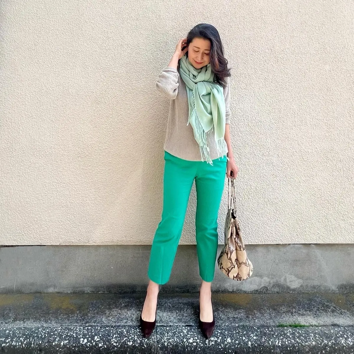 グリーンのクロップドパンツ、グレージュのミドルゲージニット、ライトグリーンのストール、茶のパンプス、パイソン柄のバッグ