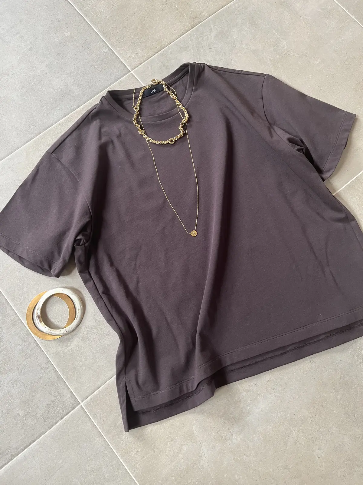 ダークブラウンと相性のよい、ゴールドのジュエリーを重ねて