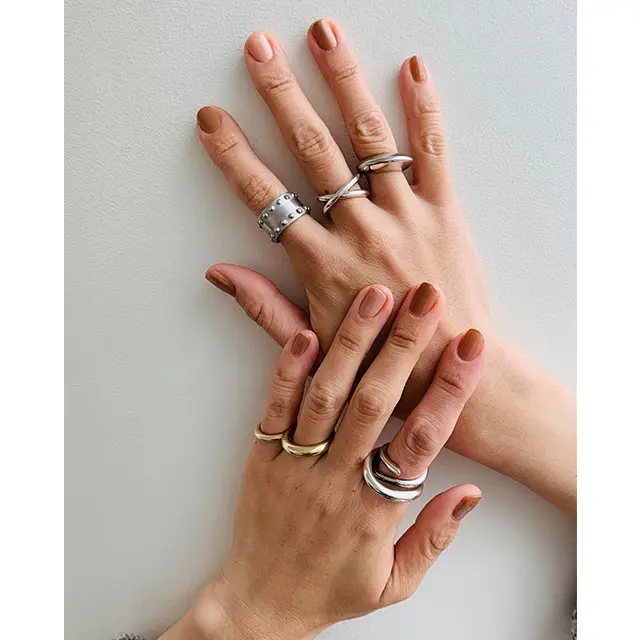 ボリュームあるシルバーリングの重ね付けで「辛口」な手元に