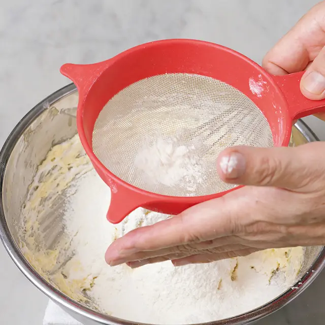 薄力粉の半量をふるい入れ、同様にほぼ見 えなくなる程度に混ぜる。