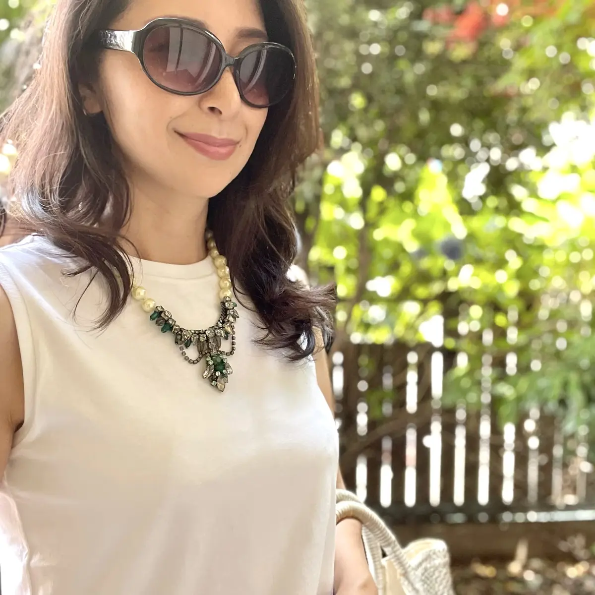 白のノースリーブTシャツにパールとビジューのショートネックレス