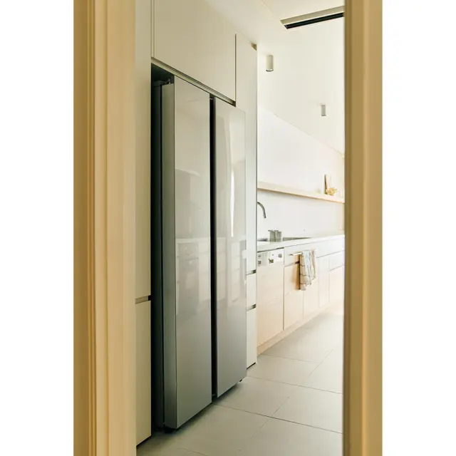 蔵庫まわりの収納部分もリノベーション前のまま再利用し、新たに白系のメラミン材の扉に付け替えた。ここには食品ストックなどを収納。買い物から帰ると玄関からすぐのパントリーに直行し冷蔵庫へというムダのない動線。反対側には洗濯機もあるため、キッチンとパントリーで家事が完結する