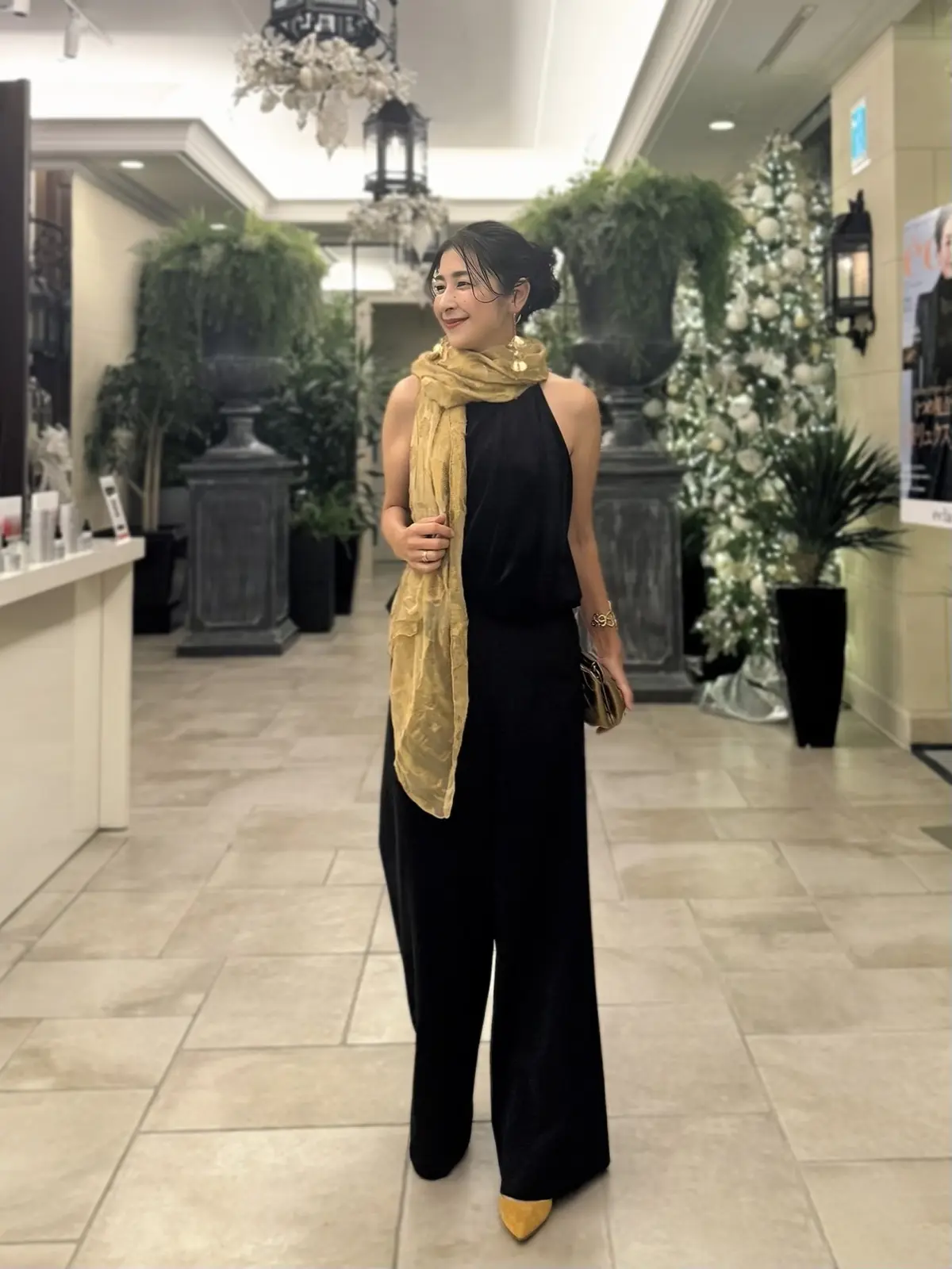 ソワレ・ドゥ・エクラ　エクラプレミアム　優美なセミワイドパンツ　ザラ　ホルターネックトップス　アラフィフパーティーコーデ　ゴールド色のストール、ゴールド色のバッグ　キャメル色のパンプス　50代パーティーコーデ