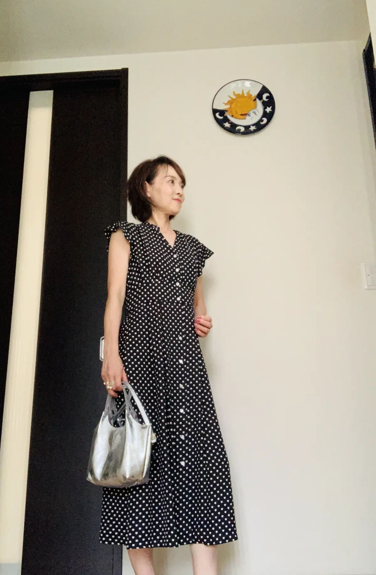黒のドット柄ワンピースとシルバーのバックをコーディネート