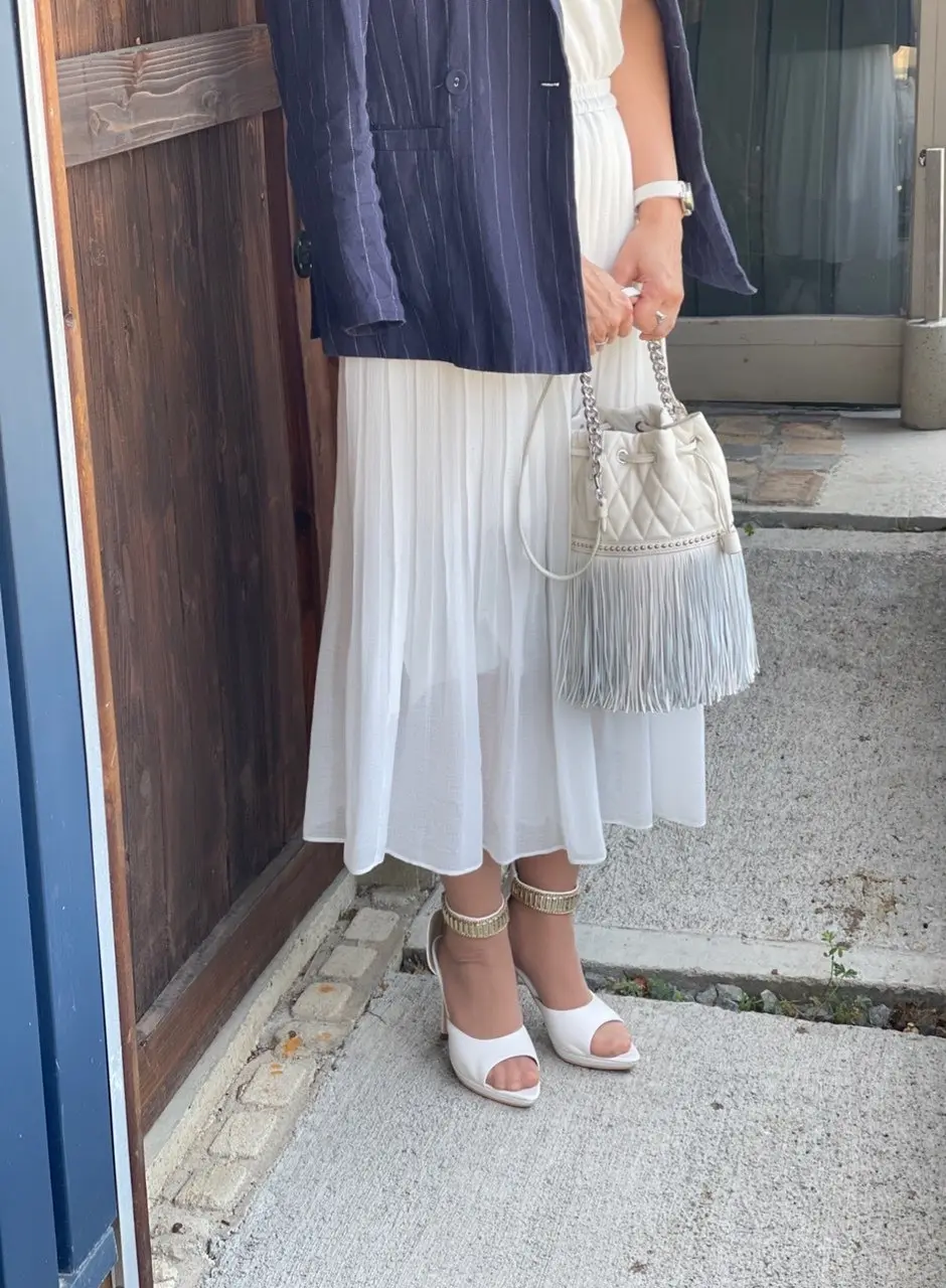白いロングスカート、白いパンプス、白いバッグ