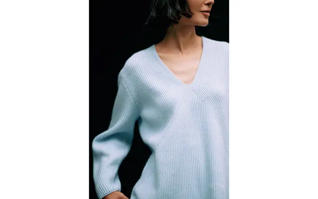 フロントで交差する編み地の変化とVネックの組み合わせで上半身をほっそりと。