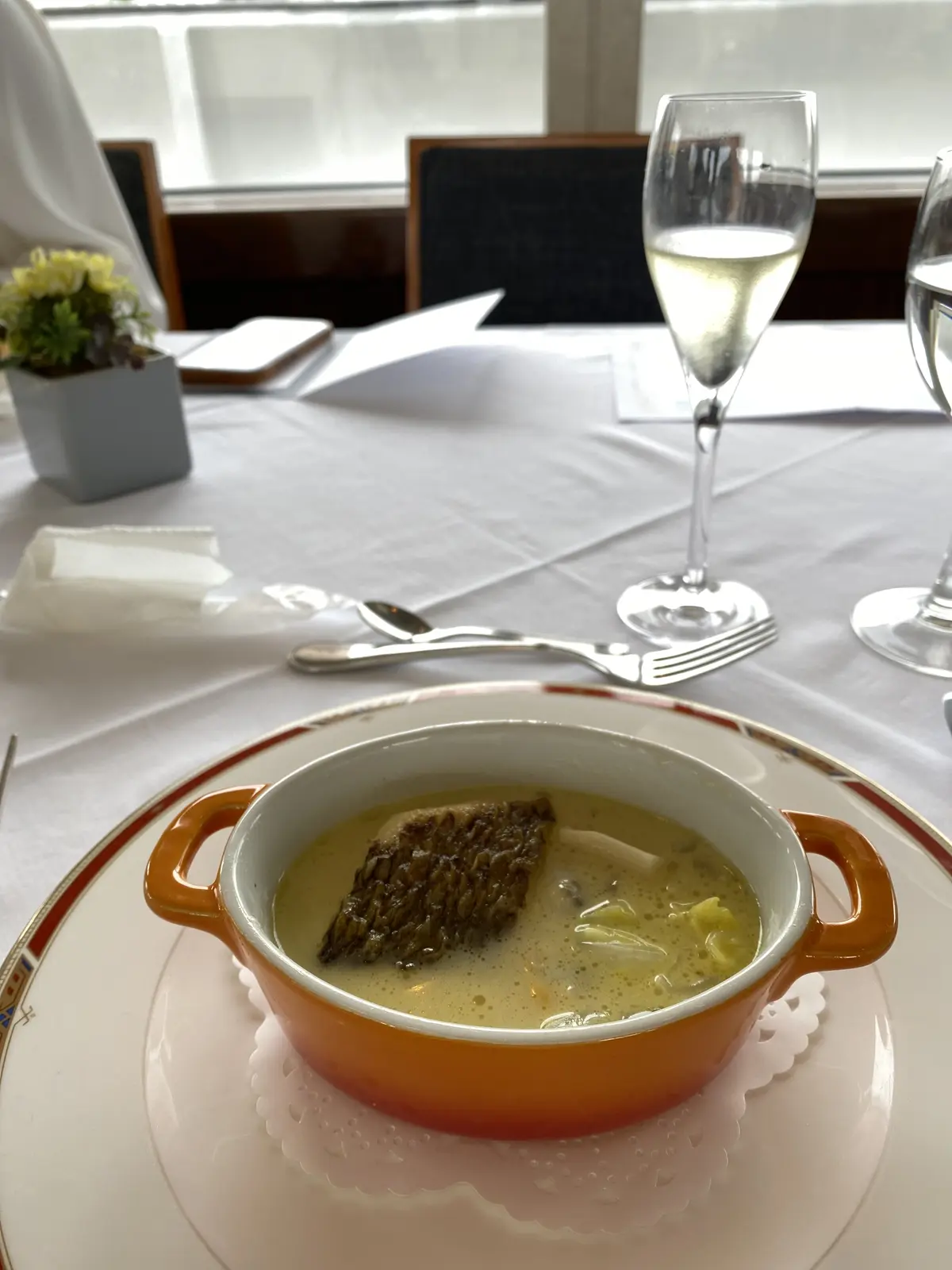 オレンジの器に盛られた鮮魚のポトフ仕立てローズマリーとレモンの香り、