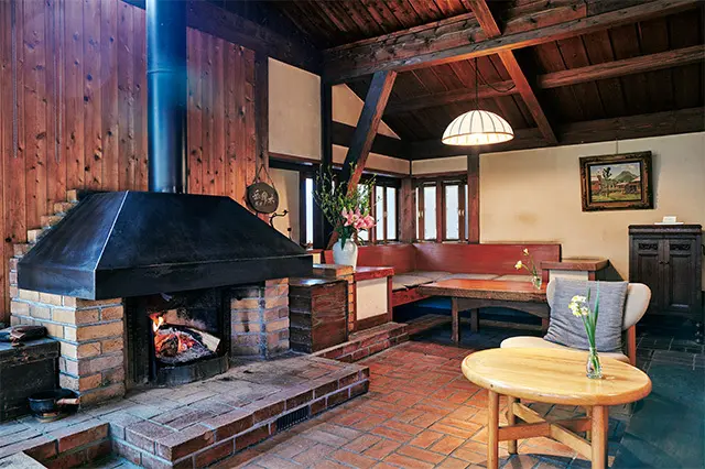 「談話室」は山荘風の趣。ここを定宿にしていた作家の著書やアート本が 並ぶ本棚や絵画に囲まれ、素敵な別荘へ招かれた心地になる