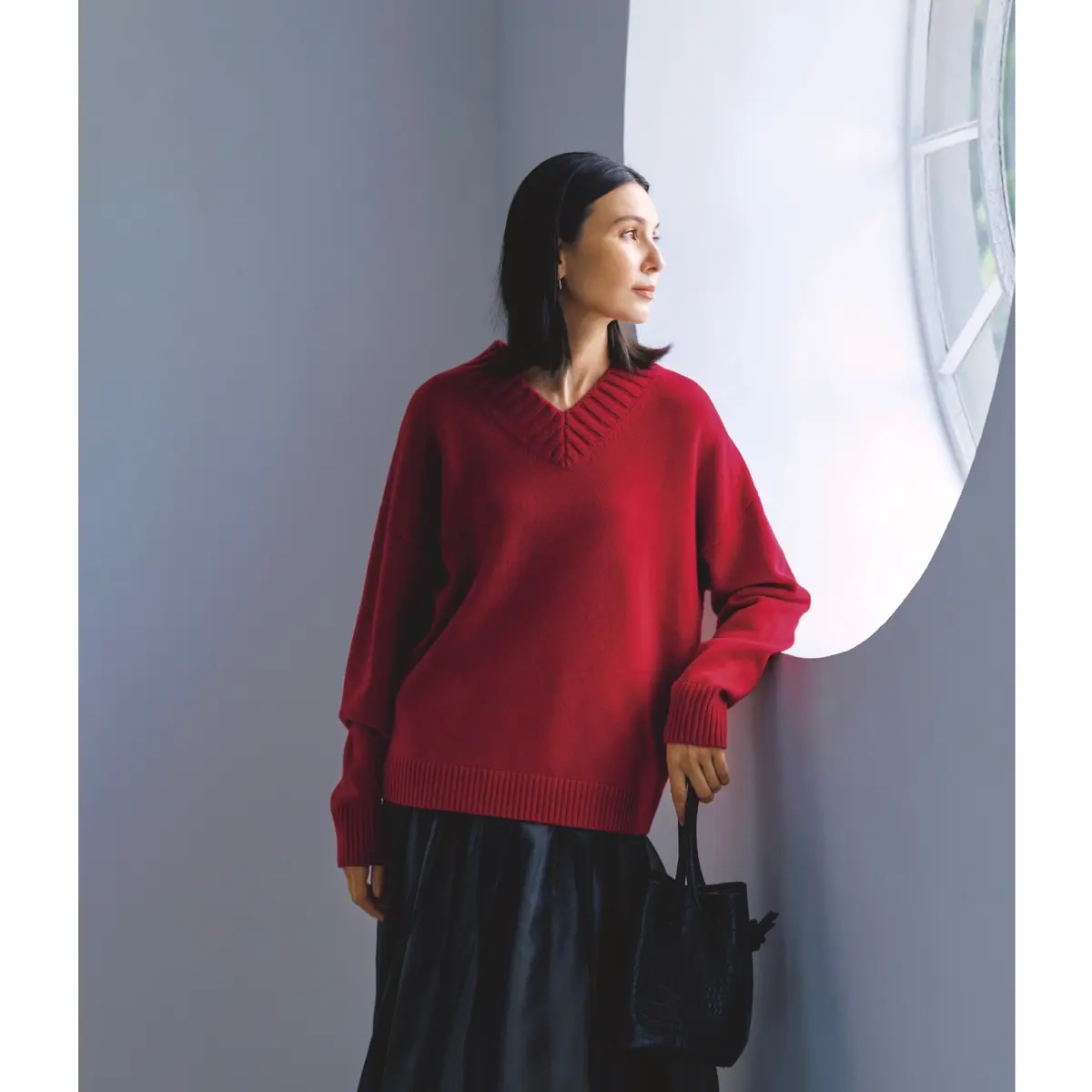 赤のVネックニットに黒フレアースカートを合わせたコーディネート　モデル・田沢美亜