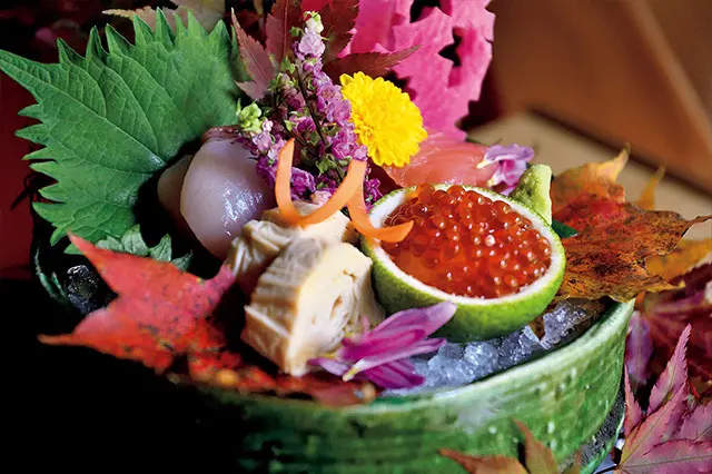 夕食・朝食は完全個室の食事処で。旬の食材を創作和食で仕立てる。華やかな刺身の盛り合わせ。