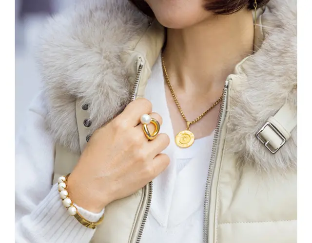 パールのバングルはケイト・スペード。存在感のあるパールとゴールドとの組み合わせが、白のワントーンに映える