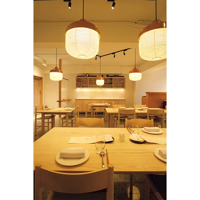 書家でもあるシェフの筆書きメニューに、料理に最適な明るさの照明がともされて