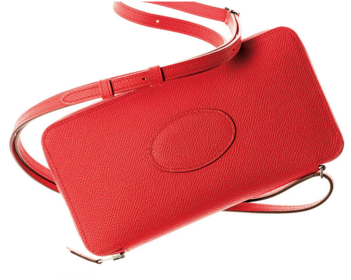 たっぷりとマチがあり、スマートフォンやリップなど貴重品 まで収納できる。モダンなオレンジが装いにも華やかさを加え て。ショルダーストラップは取りはずし可能。札入れ1、小銭 入れ1、カード挿し4、ポケット1。ウォレットバッグ（10×21 ×2）￥539,000／エルメスジャポン（エルメス）　