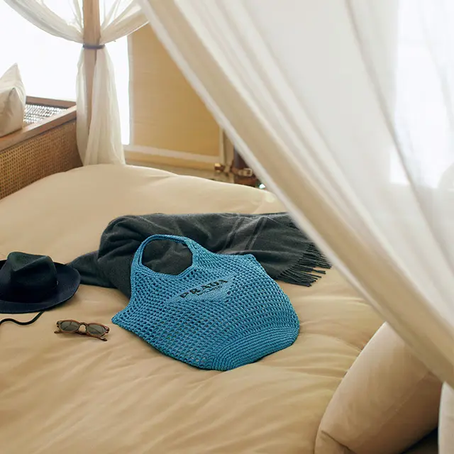 小粋なラフィアのトートバッグと、辛口カラーの小物を旅のお供に