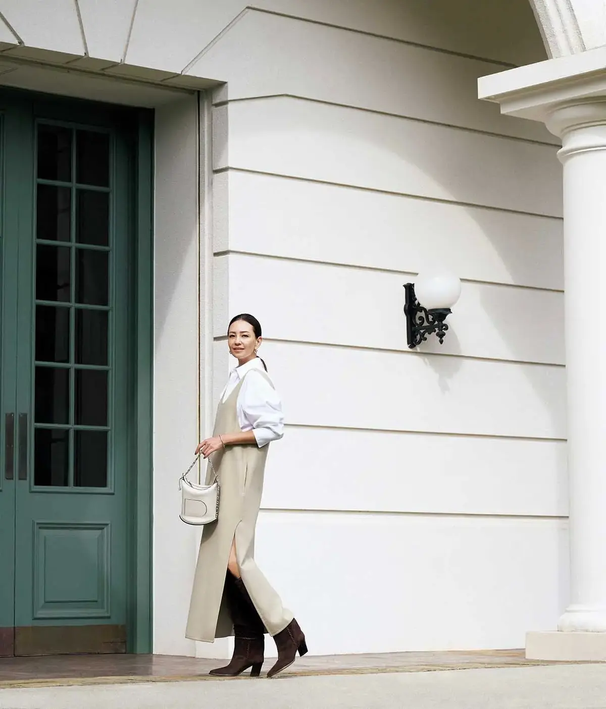 スリットからのぞく、素肌とロングブーツの巧みな駆け引き。エクリュ配色にキレのいい色香が漂う