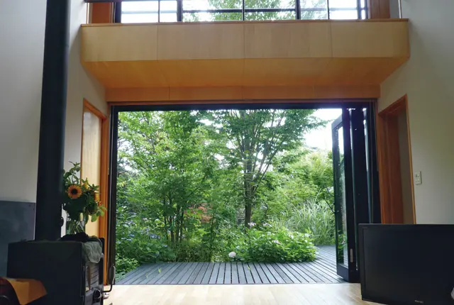 南北に抜けた明るいリビングの外に広いデッキと庭が広がる