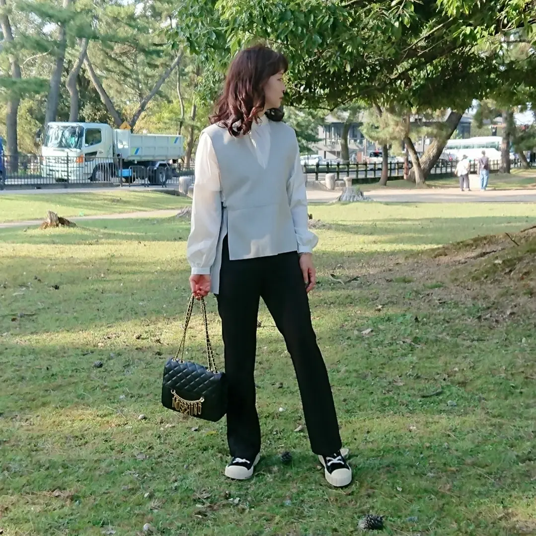 ライトグレーベスト  黒いパンツ  白いブラウス  スニーカー