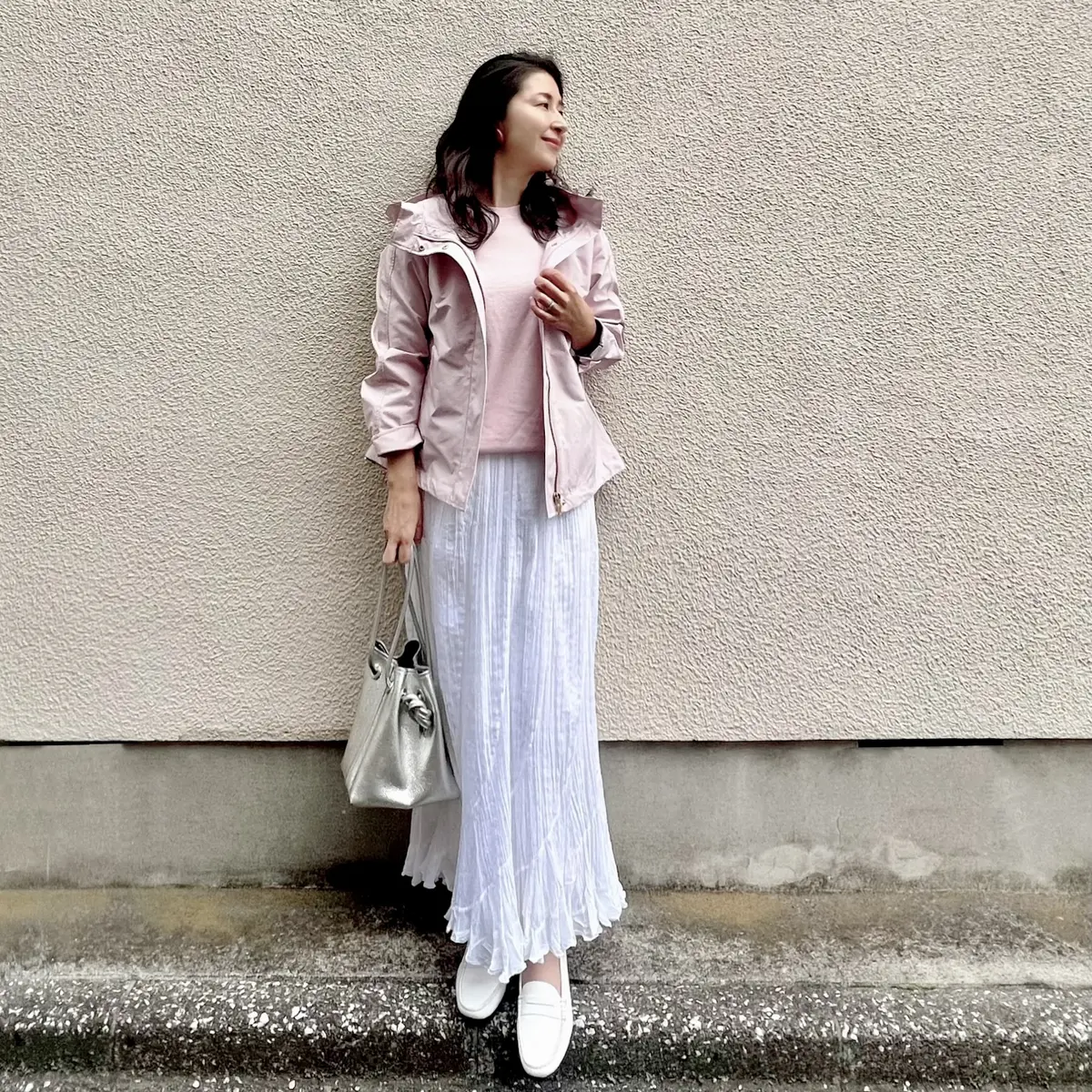ピンクのマウンテンパーカー　ピンクのニット　白のロングスカート　白のローファー　シルバーのバッグ